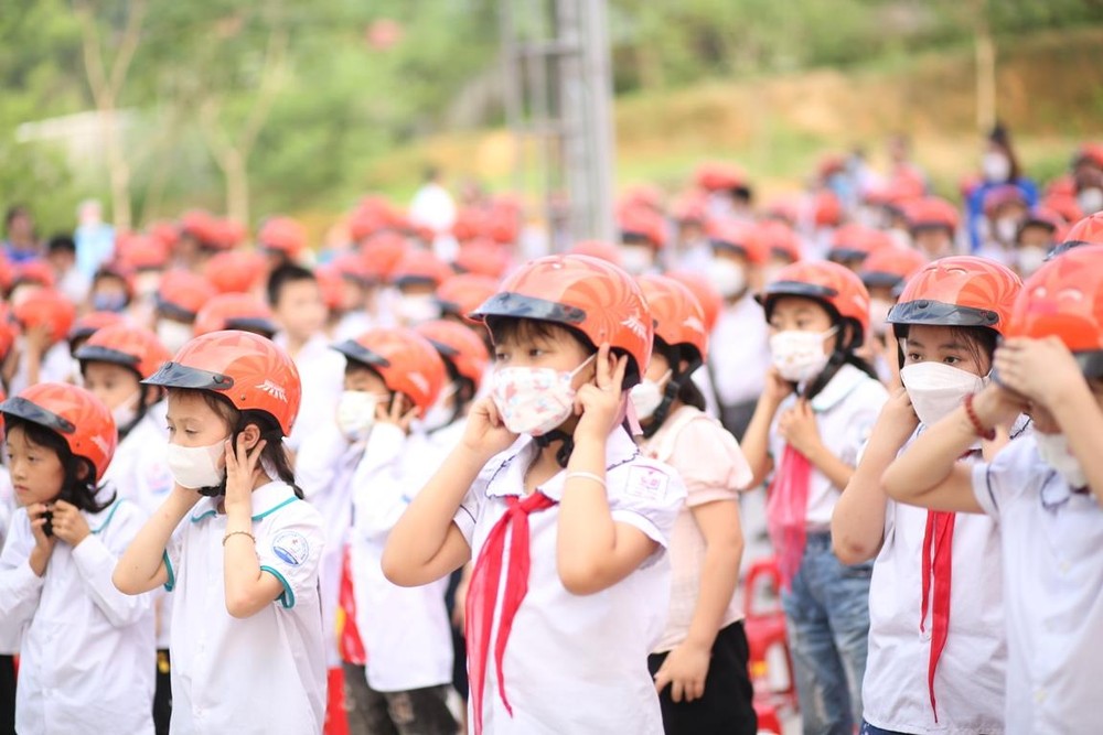 Học sinh tiểu học thực hành đội mũ bảo hiểm đạt chuẩn và đúng cách. (Ảnh: CTV/Vietnam+)